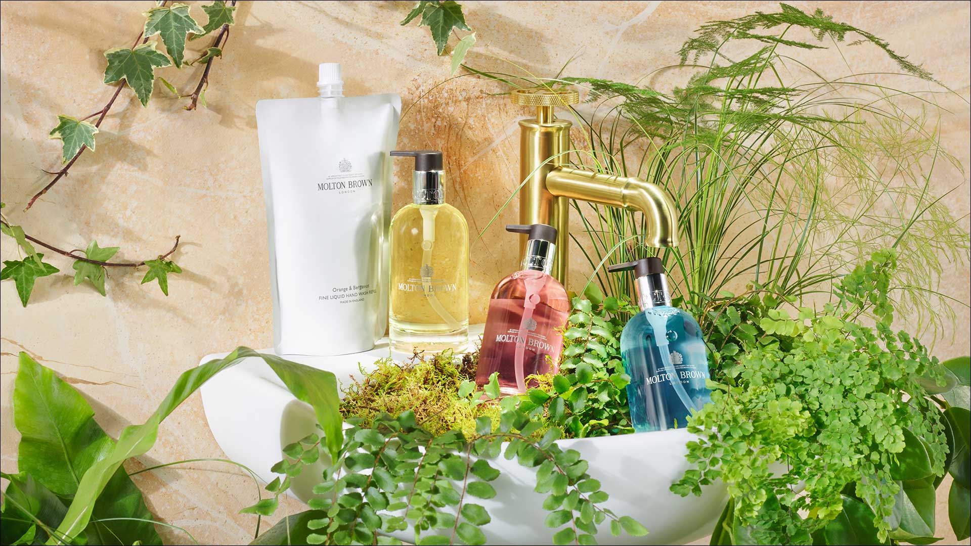 Selection of Molton Brown liquid soaps surrounded with foliage