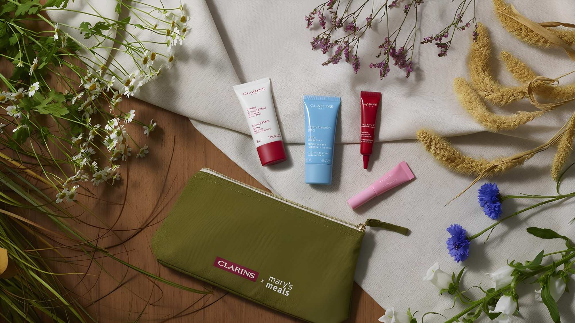Clarins & Mary's Meals organic travel bag with 4 beauty skincare essential gift items from Goulds in Dorchester.